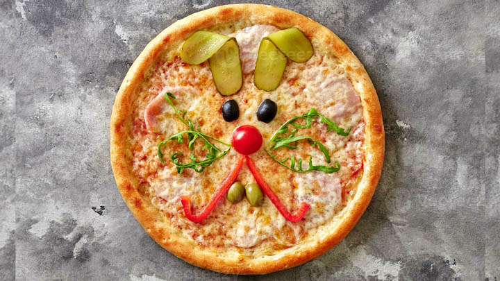 Pizza med kaninansikte gjort av gr&ouml;nsaker.