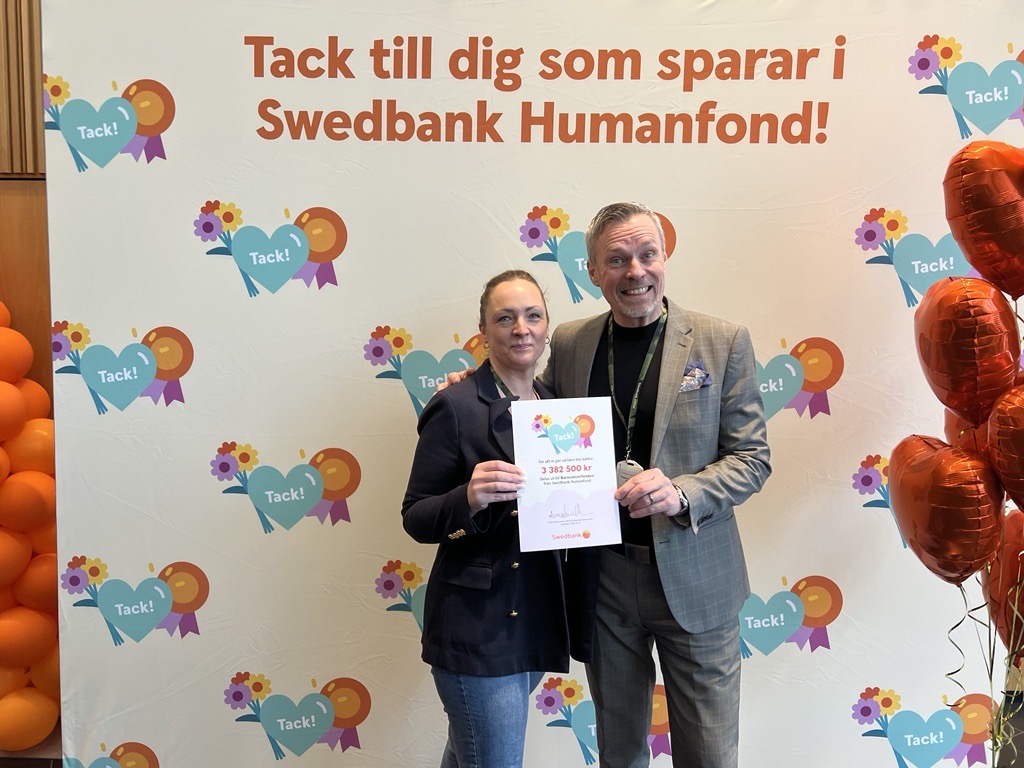 Sara och Magnus h&aring;ller i en check fr&aring;n Swedbank Humanfond