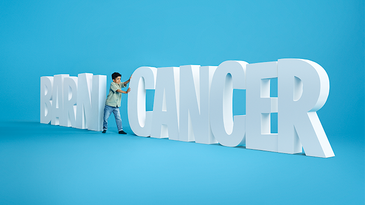 Barn som symboliskt puttar bort ordet cancer från ordet barncancer.